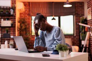 Image of a tired woman sitting at a desk